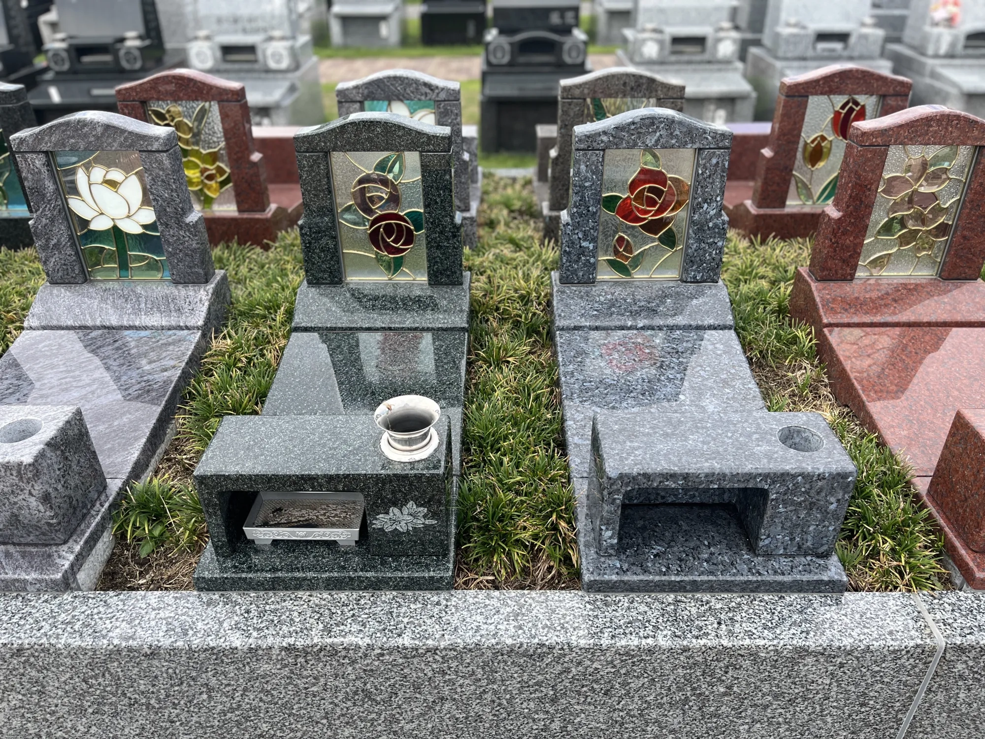 バラとユリの彫刻があるコローレ墓石