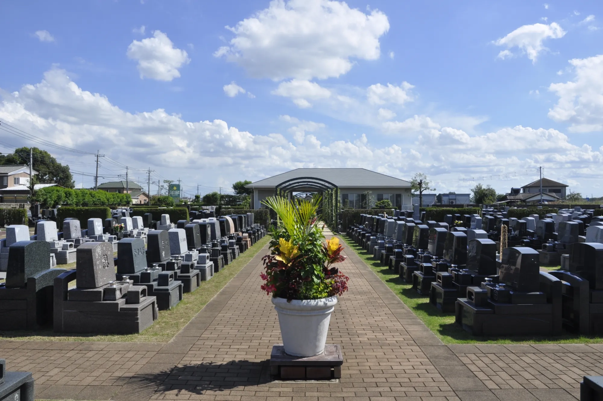 青空の下、花鉢を中心に墓域を真正面から見た景観